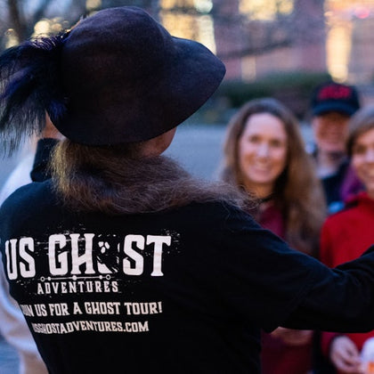Tour guide making a tour group laugh while they hold EMF detectors, picking up on a spiritual activity