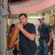 Three people are in a submarine interior. One man is holding a cylindrical object near a torpedo tube.
