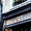 A sign reading 'The Ten Bells' above a doorway, with a flower box and ornate architectural details visible.