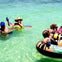 Relaxing on rafts with pool noodles in clear waters—a perfect snapshot of carefree bliss and summer leisure.