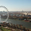 Aerial view of the London Eye beside the River Thames with surrounding buildings and a park in the foreground.