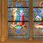 A stained glass window depicting a biblical scene with an angel and a praying figure in a colorful, intricate design.