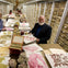 A group of people examining botanical specimens in a library-like archive filled with shelves of preserved plants.