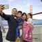 A family of four taking a selfie on a boat with the Golden Gate Bridge in the background.