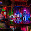 A colorful stage setup with mannequins dressed as angels and musicians standing under vibrant lighting in a decorated room.