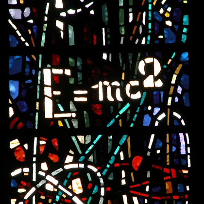 A stained glass artwork featuring the equation E=mc² prominently, surrounded by colorful abstract patterns.