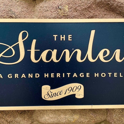 A sign reading 'The Stanley, A Grand Heritage Hotel, Since 1909' on a stone background.