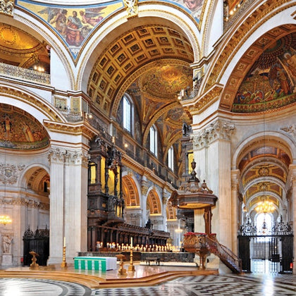 A grand interior of a cathedral with ornate decorations, high arches, detailed ceilings, and a lit altar with candles.