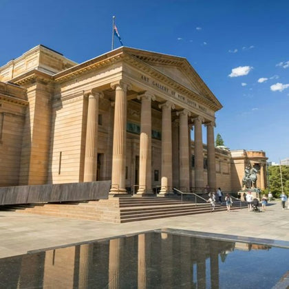 A neoclassical building with columns and a triangular pediment, labeled 'Art Gallery of New South Wales,' under a clear sky.