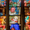A stained glass window depicting a nativity scene with Mary, Joseph, baby Jesus, an angel, and shepherds in vibrant colors.