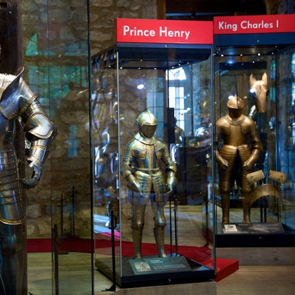 Display cases with knight armor labeled for Prince Henry and King Charles I in a museum setting.