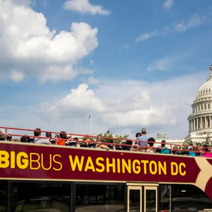 A double-decker sightseeing bus labeled "Big Bus Washington DC" near the US Capitol under a partly cloudy sky.