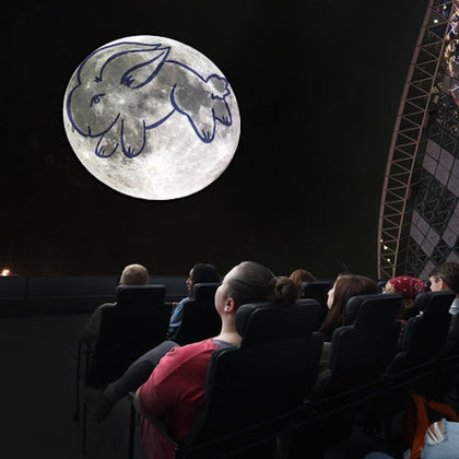 spectators at adler planetarium enjoying a projection of the moon and stars