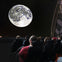 spectators at adler planetarium enjoying a projection of the moon and stars
