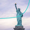 The Statue of Liberty holding a torch, viewed from below, with a curved green line overlaying the image against a cloudy sky.