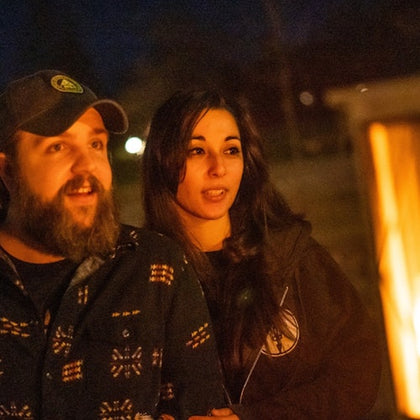 Couple listening to stories next to a lantern