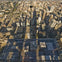 View from a glass observation deck high above a cityscape featuring numerous buildings, roads, and a distant highway.