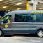 Grey van with "The Fairly..." partially obscured text and a circular logo parked under a concrete structure with a "15" sign.