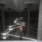 A dimly lit room with many columns and glowing light beams crisscrossing the space, connected to a central pillar with a red light.