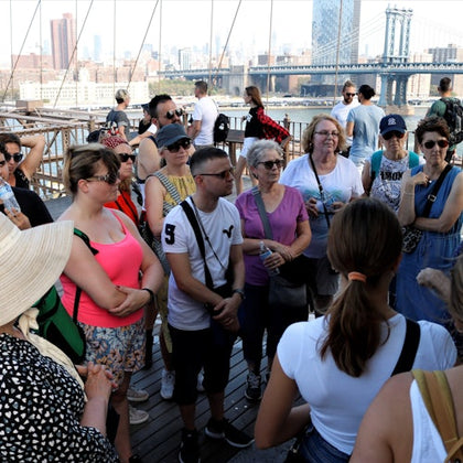 Capture the moment as our tour group listens to our guide's captivating stories on the Brooklyn Bridge.