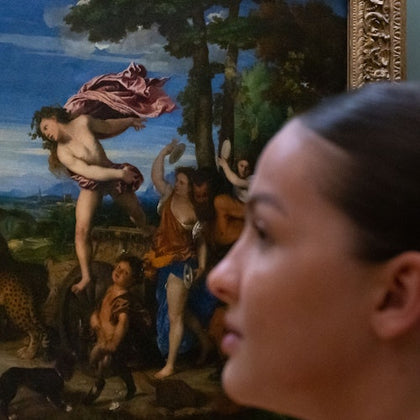 A blurred close-up of a woman in profile in front of a classical painting featuring mythological figures in a landscape.