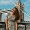 A tourist is having her photo taken outside the Tower Bridge.