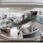People exploring a modern science museum interior with glass railings, exhibits, and a large spherical structure.