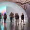 Group walking through the Chromosaturation MFAH tunnel connecting one building to another