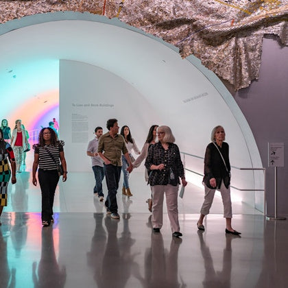 Group walking through the Chromosaturation MFAH tunnel connecting one building to another