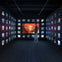 A person stands in a dimly lit exhibit room with illuminated screens displaying various images on the walls.