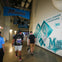 People walking through a hallway with Miami Marlins decorations, including banners and wall graphics about their championships.