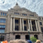 A large, classical-style building with tall columns and a dome, viewed from the front on a cloudy day.