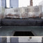 A reflecting pool with a central square void surrounded by a modern building and trees, within an urban setting.