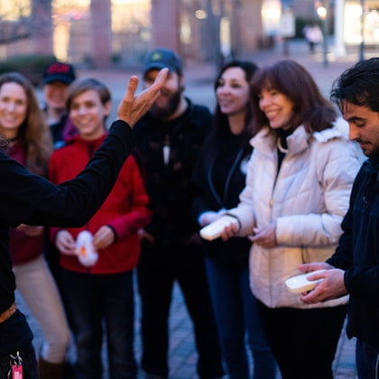 Tour guide making a tour group laugh while they hold EMF detectors, picking up on spiritual activity