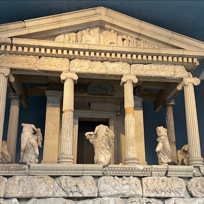 A detailed model or reconstruction of an ancient Greek-style temple with columns and sculptural decorations.