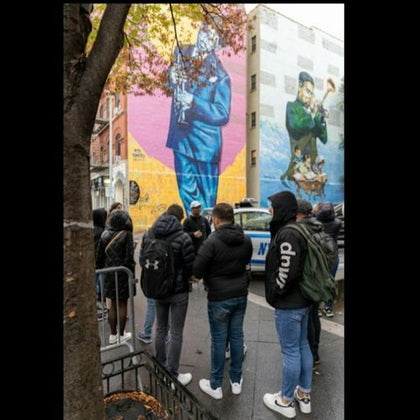 A captivating photo of our tour guest standing in front of an iconic painting in Harlem.