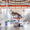 Visitors observe a dinosaur skeleton exhibit in a spacious, well-lit lobby with glass walls and a sign reading "Byers Lobby" above.