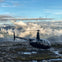 A helicopter landed on a mountain with mountain views in the background.