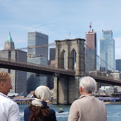 The cruise sails under the Brooklyn Bridge with views of Lower Manhattan