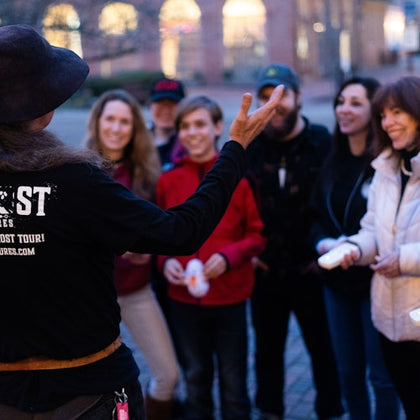 Tour guide entertaining guests as they hold EMF detectors used to pick up on ghost activity