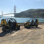 Two compact yellow and black electric vehicles parked near water with the Golden Gate Bridge visible in the background.