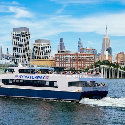 A ferry labeled "NY Waterway" sails on a river with a cityscape background featuring modern and classic skyscrapers.