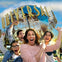 A group of people excitedly posing in front of the Universal Studios globe.