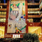 A colorful mural on a building facade depicting abstract shapes, hands, and a face, with lit windows around it.