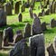 An old cemetery with numerous weathered gravestones of various shapes and sizes, set on a grassy area.