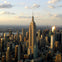 Aerial view of a city skyline with the Empire State Building prominently in the center and other skyscrapers surrounding it.