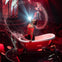 A performer splashing water while posing in a bathtub on stage with dramatic red lighting and an audience in the background.
