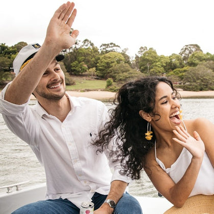 Two guests onboard a GoBoat waiving to passers by 