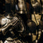 A suit of medieval armor with clasped gauntlets on display, surrounded by other armors in the background.