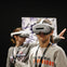 Two individuals wearing VR headsets in a dimly lit environment, one in the foreground and one slightly blurred in the background.